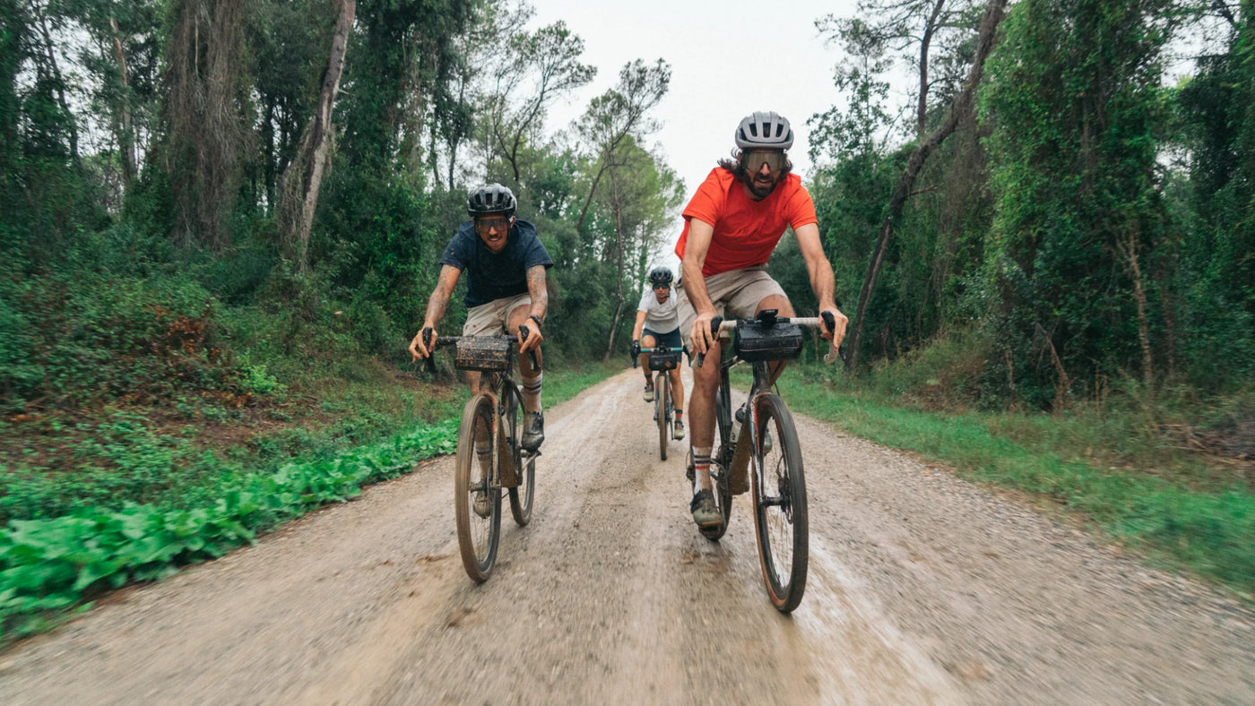 A group of cyclists ride a dirt track in CHPT3 clothing