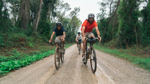 A group of cyclists ride a dirt track in CHPT3 clothing