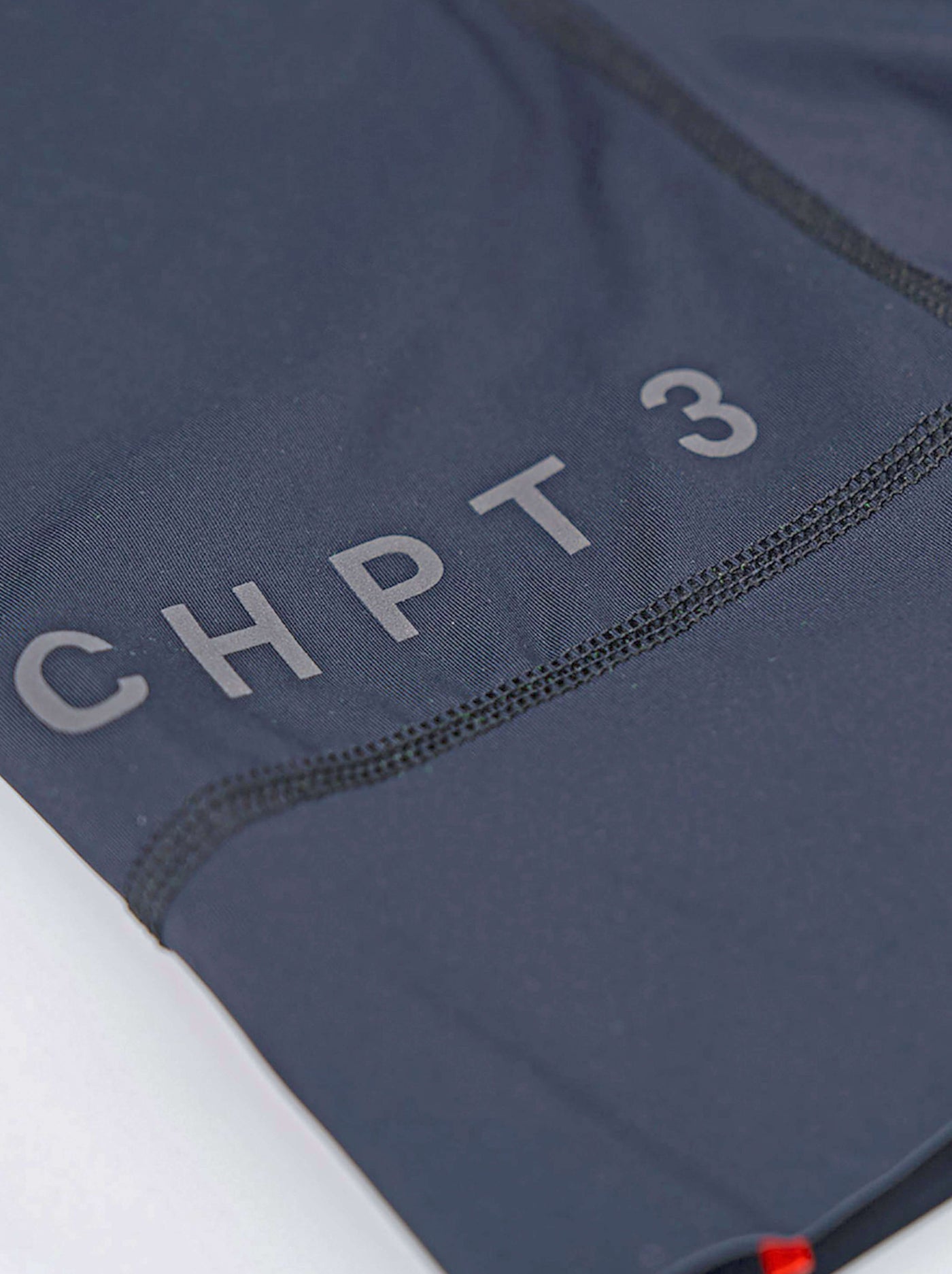 CHPT3 men's Grand Tour Bib shorts, in Outer space Blue close-up showing logo #color_outer-space-blue
